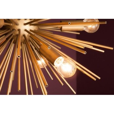 designerska wisząca lampa w złotym kolorze w kształcie słońca
